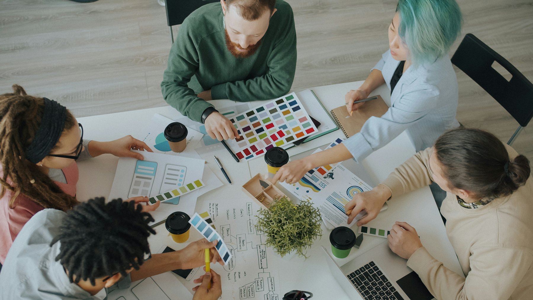 Team arbeitet mit Farbmustern und Entwürfen an einem Tisch